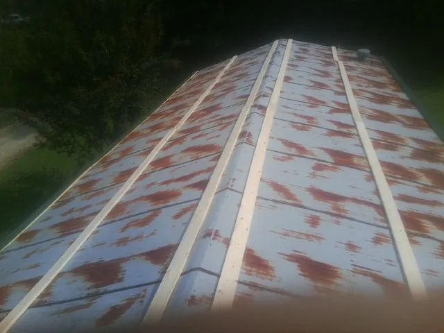 Rusted metal roof panels with new wood purlins before replacement — Storm Damage Roof Repair in Chicopee by Roofing Brothers