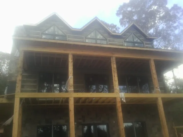 Dormers and porch framing on a large log home under construction — Roof Coating work by our crew in Chicopee