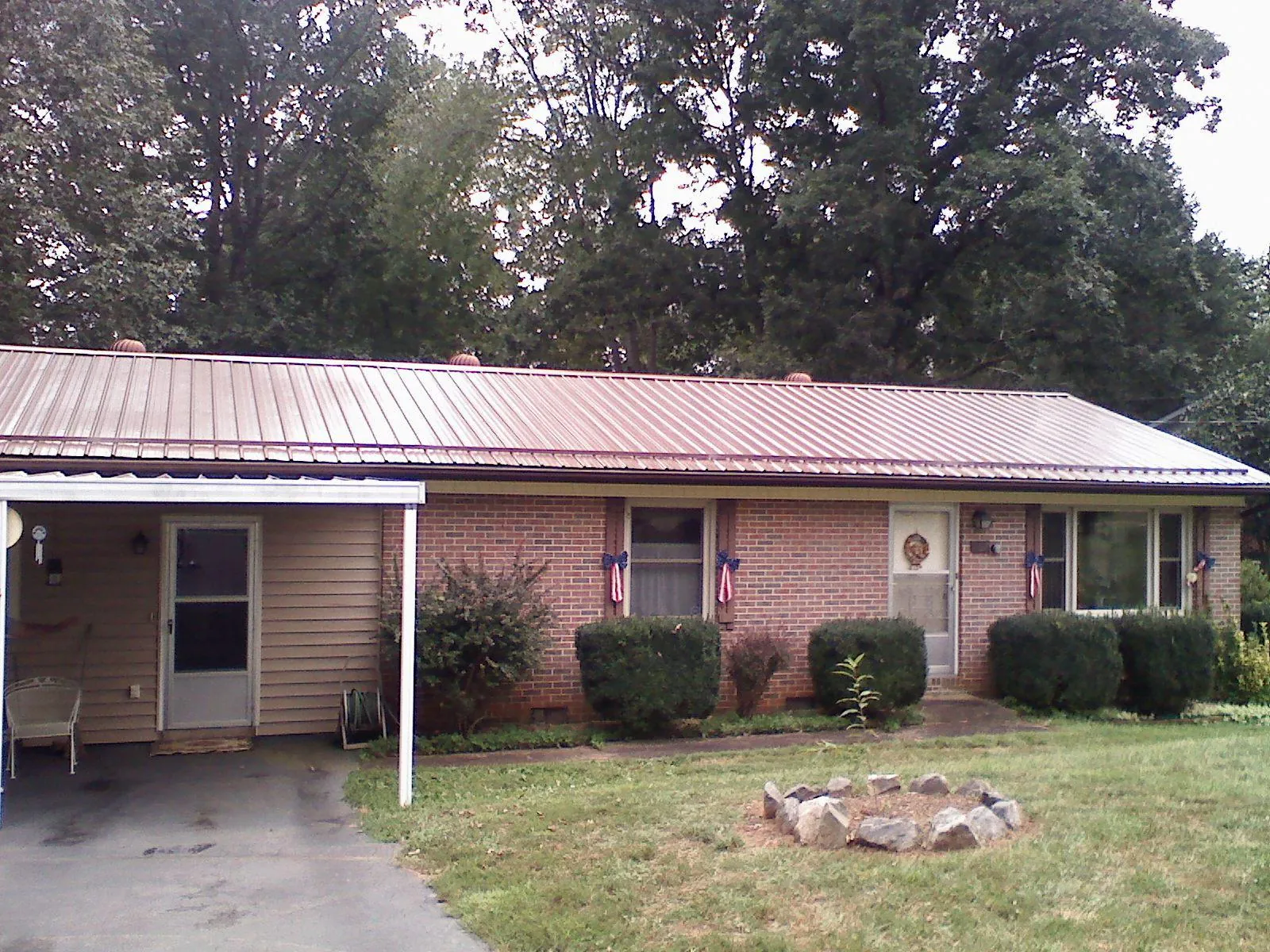 Bronze metal roof and carport on a brick ranch home — Roof Repair work by our crew in Chicopee